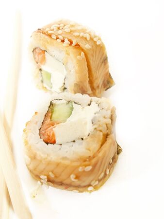 two sushi roll with omelette and eel and chopsticks over whiteの写真素材