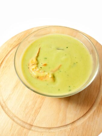 spinach cream soup with shrimp on the desk over whiteの写真素材