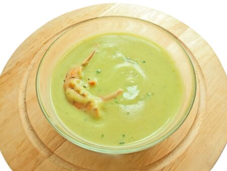 spinach cream soup with shrimp on the desk over whiteの写真素材