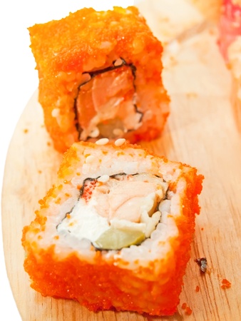 two sushi roll with salmon and red masago on the desk over whiteの写真素材