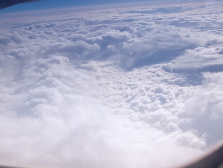 Clouds and sky as seen through window of an aircraftの写真素材