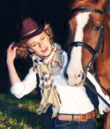 Happy cowgirl with her red horse. の写真素材
