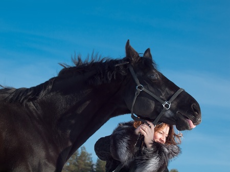 women with black horse at sky background.の写真素材