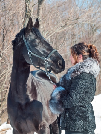 women with black horse. winterの写真素材