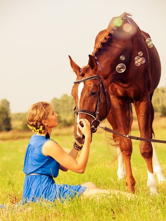 young nice  girl  with  horse in the meadowの写真素材