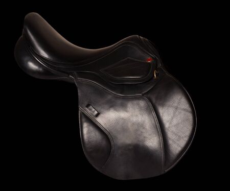Black leather premium jumping saddle isolated at black backgroundの写真素材