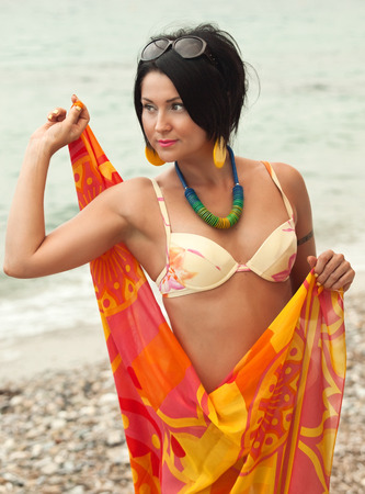 woman in bikini and pareo at sea backgroundの写真素材