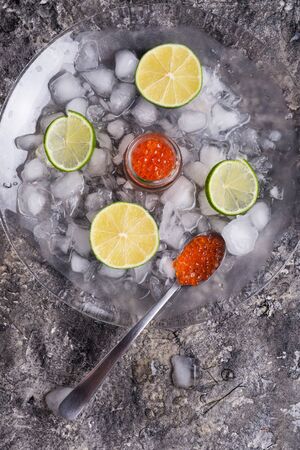 fresh red  salmon caviar with lime slices around ice. Protein luxury delicacy  healthy foodの写真素材