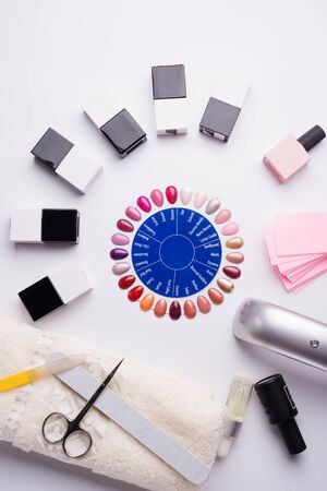 set for manicure with gell polish  bottles, LED lamp and accessoires on white background. flat layの写真素材