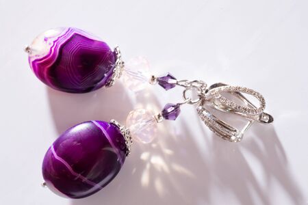 gold jewerly earrings with agat and fluorite semiprecious at white backgroundの写真素材