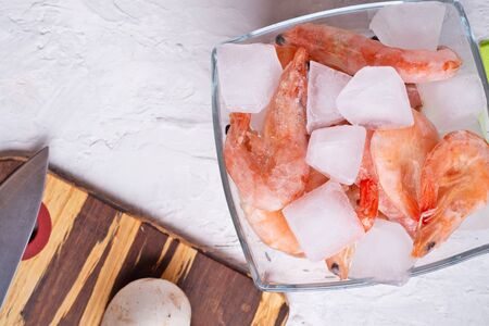 frozen shrimps  in bowl with vegetables on white table. flat layの写真素材
