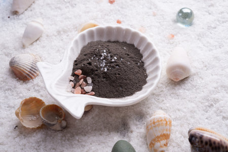 black clay around marine salt and shells background. Healthy concept.