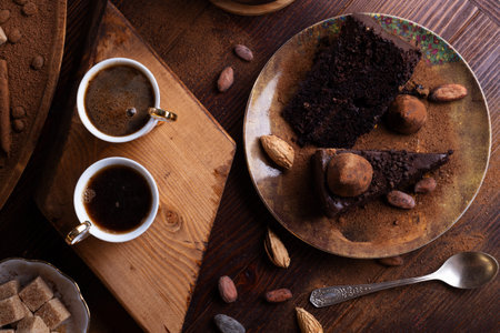 delicious chocolate truffles cakes with cups of coffee served at dark brown wooden table. life style...