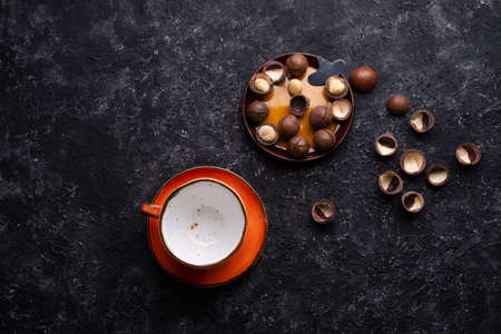 natural macadamia nuts and beautiful orange cup served at black table.food and wellness conceptの写真素材