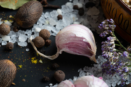 clove of fresh garlic around Spices and sea salt at black background. seasonings, Colorful natural meal additives. healthy food concept. close upの写真素材