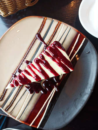 Cheesecake with berry syrup served at nice plate. cafe concept. top viewの写真素材