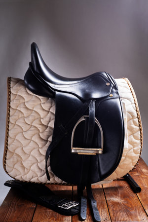 Black professional leather dressage saddle in complete with nice saddle cloth and girth puted at saddle rack travel. equestrian conceptの写真素材