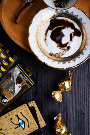 spelling coffee plate  with  coffee grounds and Tarot cards served at dark wooden table. devination conceptの写真素材