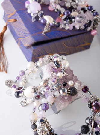 stylish jewelry bracelets with semiprecious and amethyst crystal around white background. hobby and fashion concept. close upの写真素材