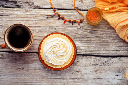 cup of coffee with delicious cream cake with orange scarf around white old style wooden background. close up. lifestyle conceptの写真素材