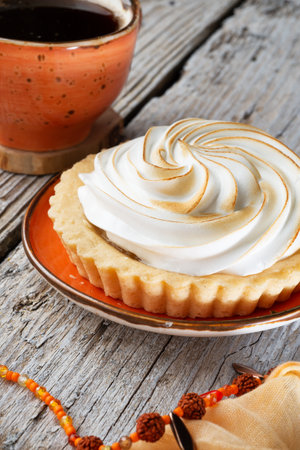 cup of coffee with delicious cream cake with orange scarf around white old style wooden background. close up. lifestyle conceptの写真素材