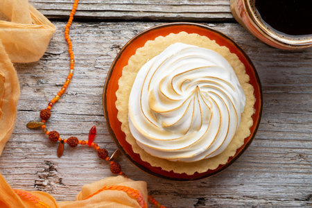 cup of coffee with delicious cream cake with orange scarf around white old style wooden background. macro shot. lifestyle conceptの写真素材