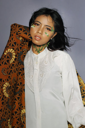 Beautiful Young Woman and Flowers in Her Face with Jarik as a head covering. Pretty woman with brown...