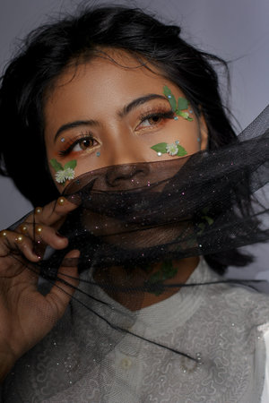 Beautiful Young Woman and Flowers in Her Face with Jarik as a head covering. Pretty woman with brown...