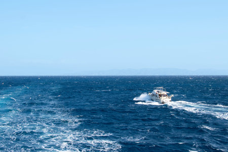 White yacht without a sail sailing on the waves of the Mediterranean Sea. A small ship in the sea...