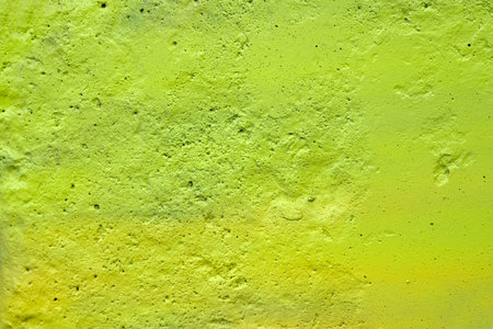 texture of a painted wall. cement plate light green color background. wall with bumps and small...