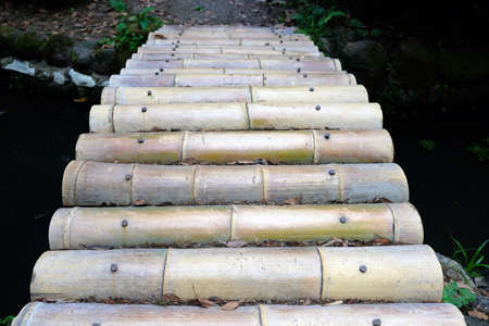 A small bridge of bamboo across the pond. Close up of bamboo pathwayの写真素材
