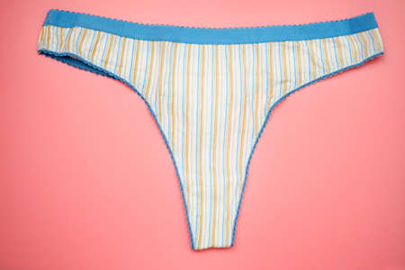 Striped thong panties on a pink background. Women's cotton underpants with blue elastic. Women's underwear.の写真素材