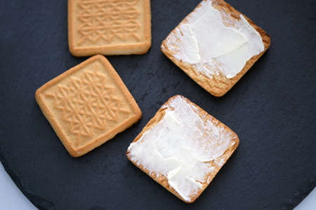 Baked milk cookies with butter top view. Shortbread cookies with butter on a black board. Tasty dessert for coffee.の写真素材