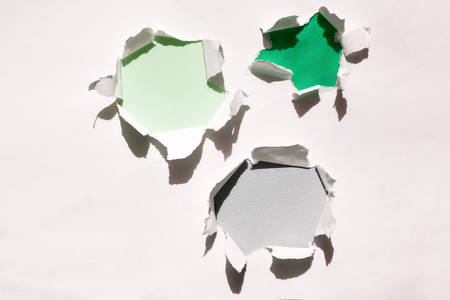 Holes in paper with different backgrounds top view. White paper with torn hollows. Empty space for text. Background for design.の写真素材