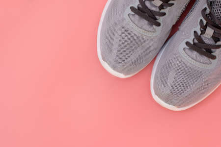 Gray sneakers on a pink background top view. Fine mesh sneakers with gray laces. Sports shoes concept of morning jogging, sports, active healthy lifestyle.の写真素材