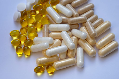 Vitamins and capsules on a white background top view. Vitamin D, E, zinc and magnesium. Food...