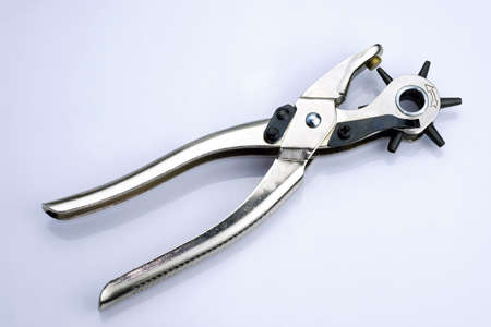 Metal hole punch for punching holes in leather goods. Device for punching holes in the sewing industry. Puncher with different attachments on a white background.の写真素材