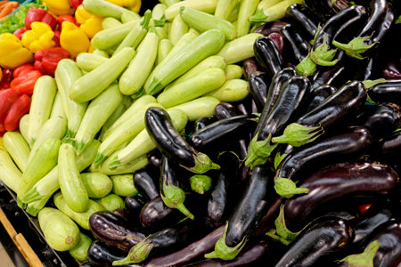 Eggplants and zucchini on the store counter in the vegetable section. A bunch of fresh vegetables at the market.の写真素材