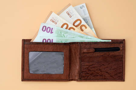 Leather brown wallet with euro bills. Banknotes of 50, 100 euros in a wallet top view. Financial crisis, lower wages, surges in the exchange rate.の写真素材