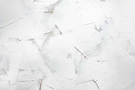 White putty background. White abstract texture of surface covered with putty. textured background of filler paste applied with putty knife in irregular dashes and strokes. Rough surface plasterの写真素材