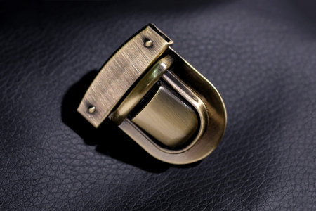 Gold shiny Lock on the bag close-up. Metal lock on a black background. Fittings for accessories. Metal parts for the sewing industry. High Quality Twist Bag Lock Latching Ladies Tote Bagの写真素材