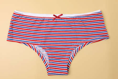 Women's panties striped on a beige background. Cotton panties top view. Red blue women's panties. cotton underwearの写真素材