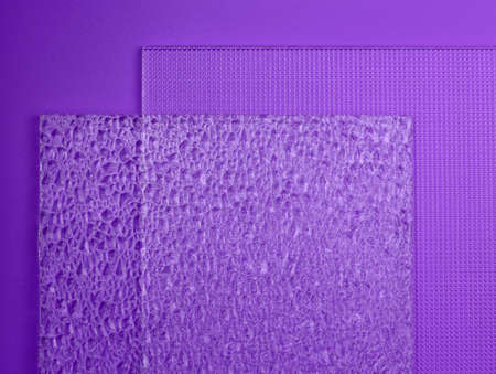 Embossed glass on a purple background top view. Two samples of different textured glass. Glass transparent embossed close-up.の写真素材