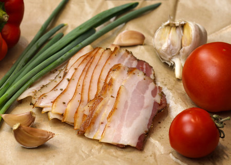 Raw smoked bacon, streaky brisket slices, fresh thin sliced bacon. Fresh pieces of lard or salo and bacon rolled with pickles. Meat delicacy, boiled pork with layers of lard, sliced.の写真素材