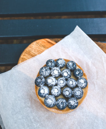 Sand basket with lemon cream and caramel. Decorated with fresh blueberries and powdered sugar.