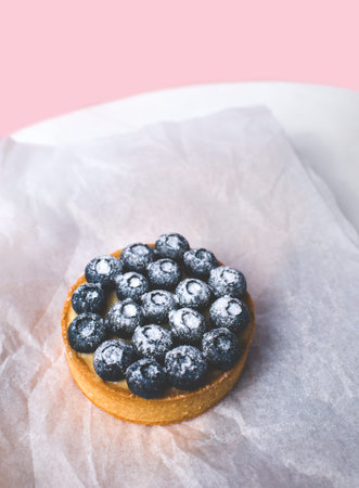 Sand basket with lemon cream and caramel. Decorated with fresh blueberries and powdered sugar.