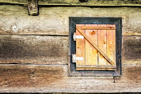 Old window cover made of wood with large metallic hingesの写真素材