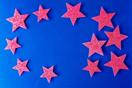 Red shiny stars against a blue background.の写真素材