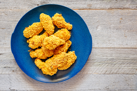 Homemade baked crispy chicken wings on a blue ceramic plateの写真素材
