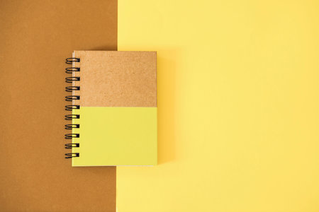 Top view of notebook on yellow-brown background.